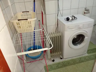 a washing machine and a basket in a laundry room at Stan na dan Apartman Kozarac in Kozarac