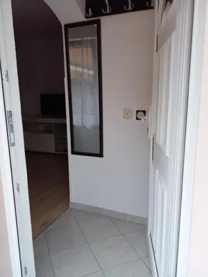 a hallway with a mirror and a door with a room at Stan na dan Apartman Kozarac in Kozarac