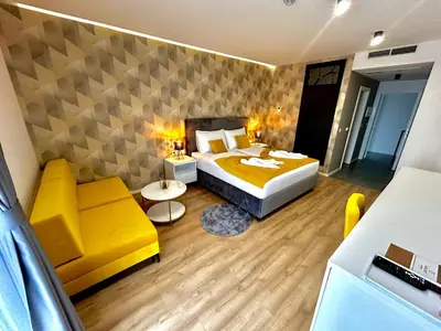 a bedroom with a yellow bed and a yellow couch at Hotel GOLD JET Bihać in Bihać