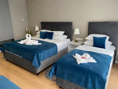 two beds with swans on them in a bedroom at Hotel GOLD JET Bihać in Bihać