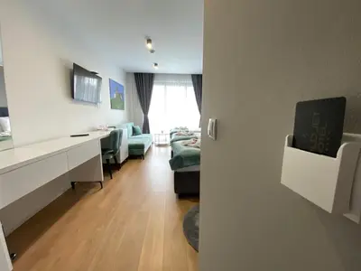 a living room with a couch and a table and a desk at Hotel GOLD JET Bihać in Bihać