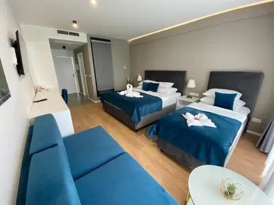 a hotel room with two beds and a couch at Hotel GOLD JET Bihać in Bihać