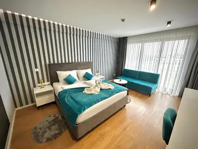 a bedroom with a bed and a blue couch at Hotel GOLD JET Bihać in Bihać