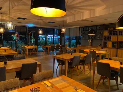 a restaurant with wooden tables and chairs and lights at Hotel GOLD JET Bihać in Bihać