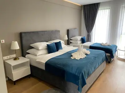 a bedroom with two beds with blue and white pillows at Hotel GOLD JET Bihać in Bihać