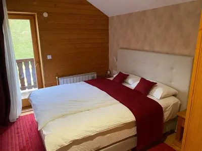 a bedroom with a large white bed with red pillows at Pansion Vlašić Ski in Šišava
