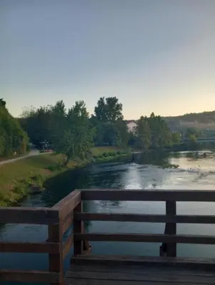 a view of a river with a wooden bridge at Apartman Emina in Bosanska Krupa