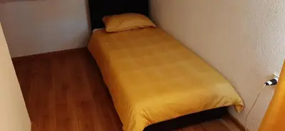 a bed in a small room with a yellow blanket at Holiday home Dani in Bihać