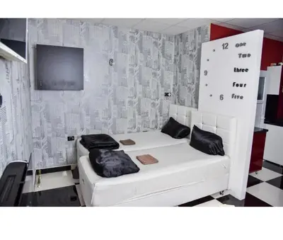 a room with a white bed and a tv at Amsterdam in Banja Luka