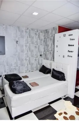 a white bed with black pillows in a room at Amsterdam in Banja Luka