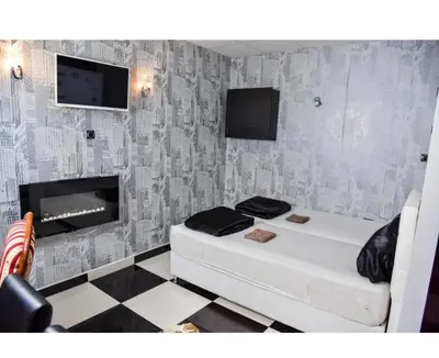 a room with a white bed and a fireplace at Amsterdam in Banja Luka