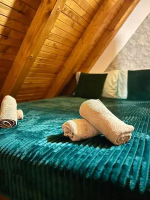 two stuffed animals laying on a green bed at Cozy Cottage Vlašić in Vlasic