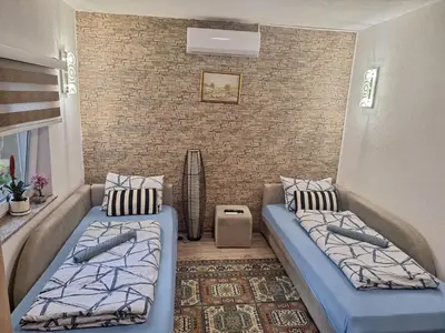 a room with two beds and a brick wall at Apartmani Villas in Visoko