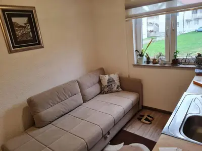 a couch in a living room with a window at Apartmani Villas in Visoko