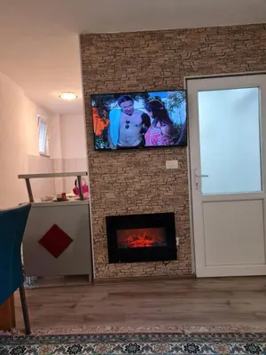 a living room with a fireplace with a flat screen tv at Apartmani Villas in Visoko