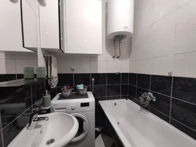 a bathroom with a sink and a washing machine at Apartman Hajduković in Banja Luka