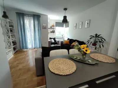 a living room with a table with flowers on it at Apartman Hajduković in Banja Luka