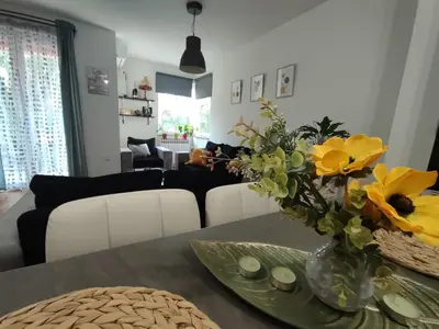 a living room with a table with yellow flowers in a vase at Apartman Hajduković in Banja Luka