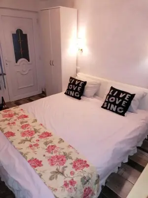 a white bed with two pillows on top of it at Apartmani Milica in Banja Luka