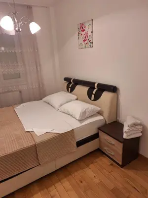 a bedroom with a bed with white sheets and a window at Elegantna oaza apartment in Banja Luka