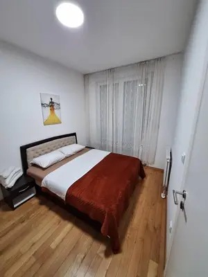 a bedroom with a large bed and a window at Elegantna oaza apartment in Banja Luka