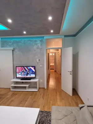 a living room with a flat screen tv on a stand at Elegantna oaza apartment in Banja Luka