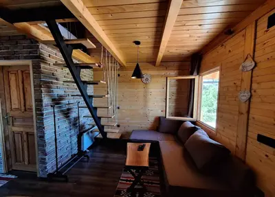 a living room with a couch and a brick wall at Koliba La Perla in Banja Luka