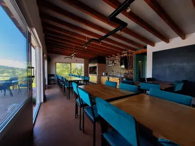 a dining room with wooden tables and blue chairs at Koliba La Perla in Banja Luka