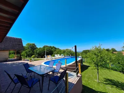 a patio with a table and chairs next to a swimming pool at Koliba La Perla in Banja Luka