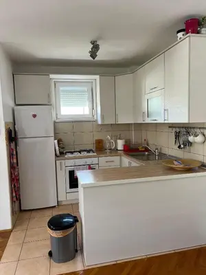 a kitchen with white cabinets and a white refrigerator at Apartment Sunny day in Livno