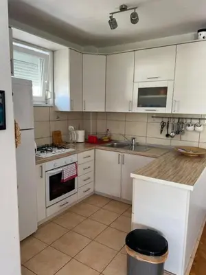 a kitchen with white cabinets and a stove top oven at Apartment Sunny day in Livno