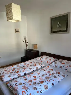 a bedroom with a bed with a flowered blanket on it at Apartment Sunny day in Livno