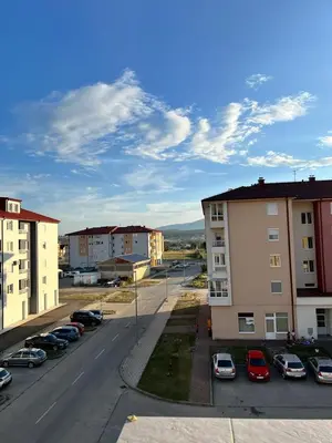 a city street with cars parked in a parking lot at Apartment Sunny day in Livno