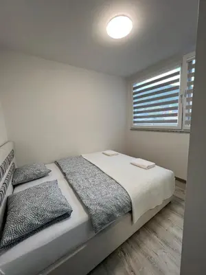 a bedroom with a bed with two pillows and a window at Apartman “ Ismar “ in Travnik