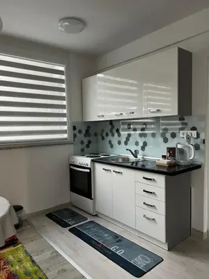 a kitchen with white cabinets and a stove top oven at Apartman “ Ismar “ in Travnik