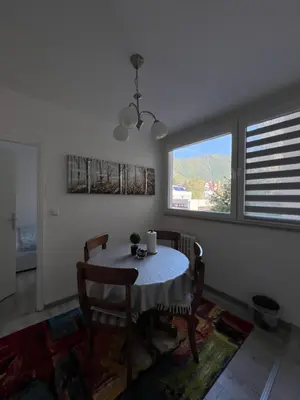 a dining room with a table and chairs and a window at Apartman “ Ismar “ in Travnik