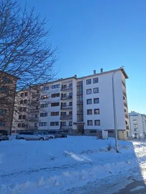 a large white building with snow in front of it at Stan na dan Grahovo in Bosansko Grahovo