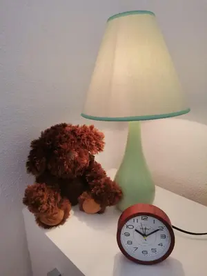 a lamp and a clock on a table next to a lamp at Stan na dan Grahovo in Bosansko Grahovo