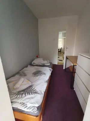 a small bedroom with a bed and a desk at Apartmani Vesna in Banja Luka
