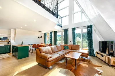 a living room with a brown couch and a kitchen at Euphoria - luxury villa in Vlasic