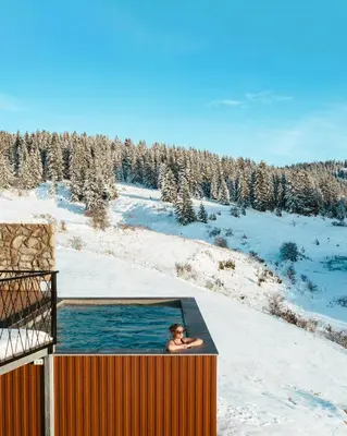 a man in a hot tub in the snow at Euphoria - luxury villa in Vlasic