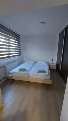 a bedroom with a bed in a room with a window at AS Apartman Visoko in Visoko