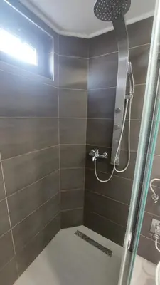 a bathroom with a shower with a glass door at AS Apartman Visoko in Visoko