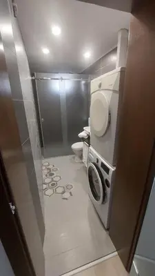a bathroom with a toilet and a washing machine at AS Apartman Visoko in Visoko