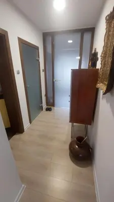 a hallway with a room with two doors and a wooden floor at AS Apartman Visoko in Visoko