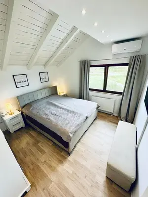 a bedroom with a large bed and a wooden floor at Vila Milincic Milincic Nest in Banja Luka