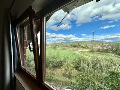 a window view of a field from a train at Vila Milincic Milincic Nest in Banja Luka