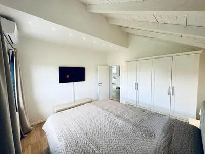 a bedroom with a large bed and a tv on the wall at Vila Milincic Milincic Nest in Banja Luka