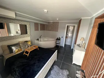 a bedroom with a large bed and a bath tub at Apartman Banja Luka CITY in Banja Luka