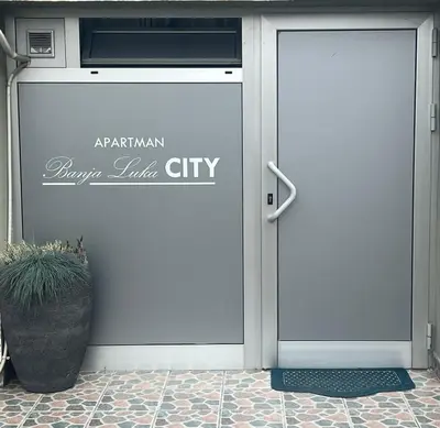 a white door with a potted plant in front of it at Apartman Banja Luka CITY in Banja Luka
